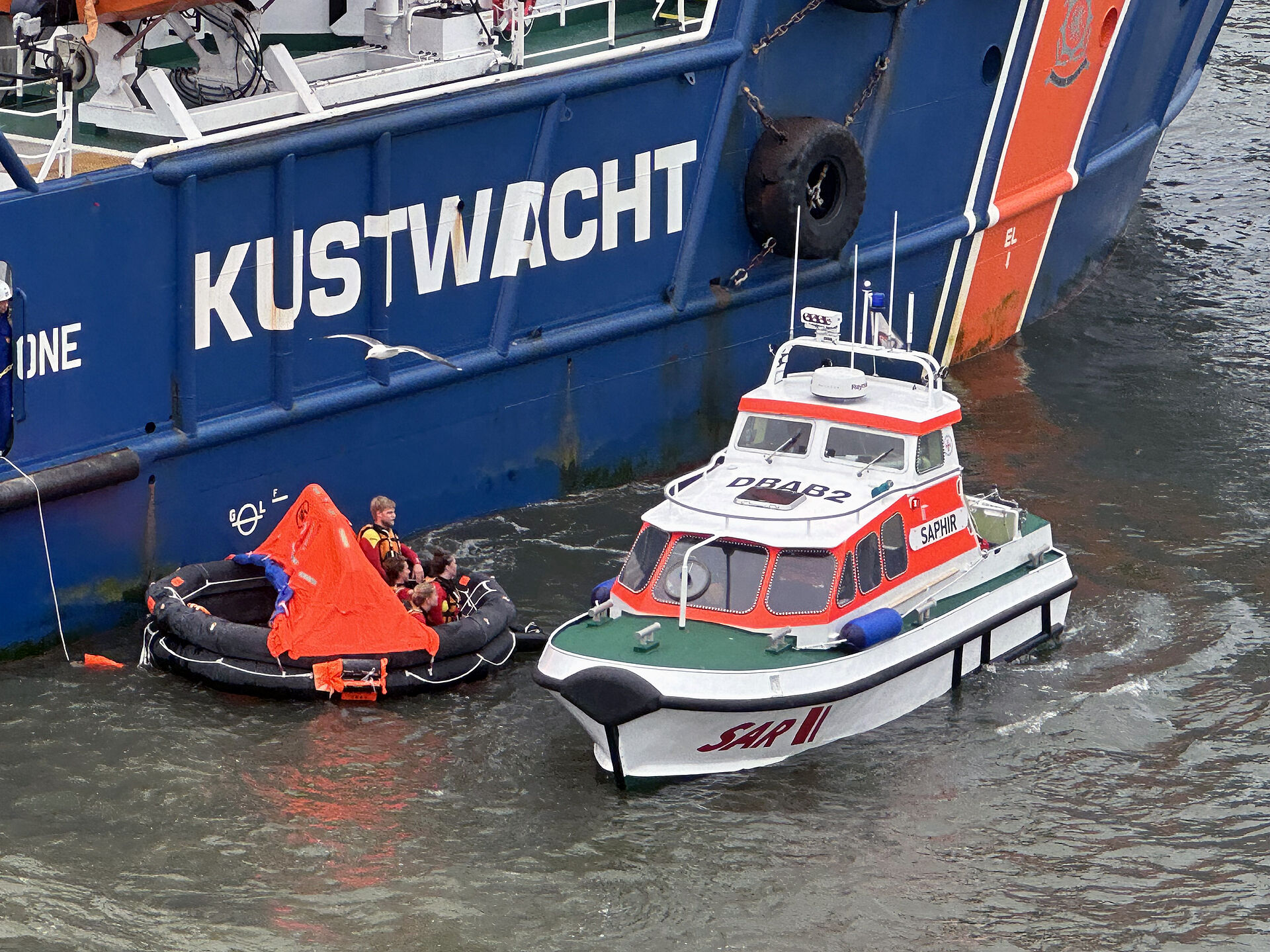 Das Tochterboot SAPHIR des Seenotrettungskreuzers FELIX SAND geht längsseits einer Rettungsinsel.
